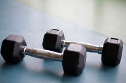 Close-up of black hexagonal dumbbells resting on a gym surface
