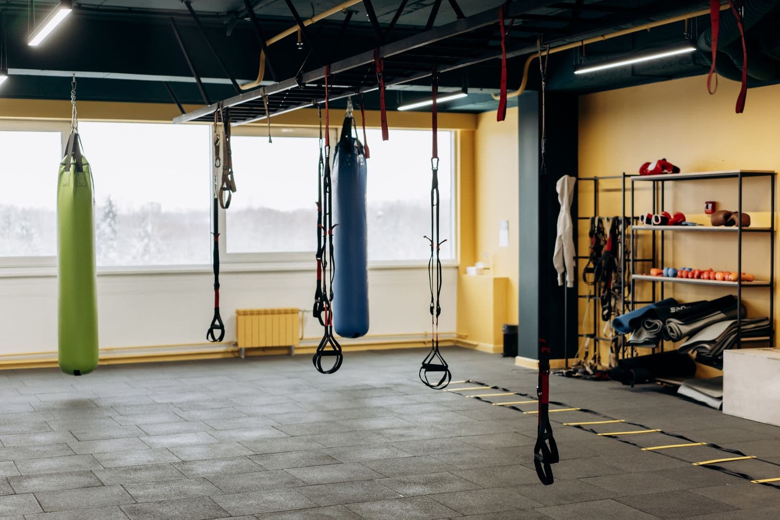 Spacious gym floor with weights, suspension trainers and large windows